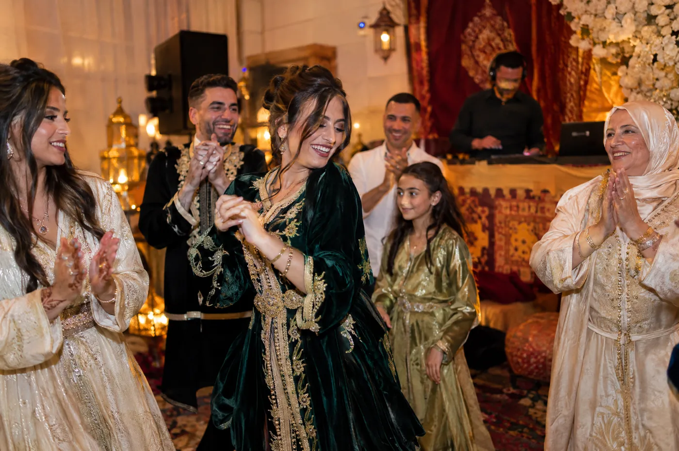 Soirée de henné : la famille en caftan danse et applaudit, le DJ joue au fond de la salle